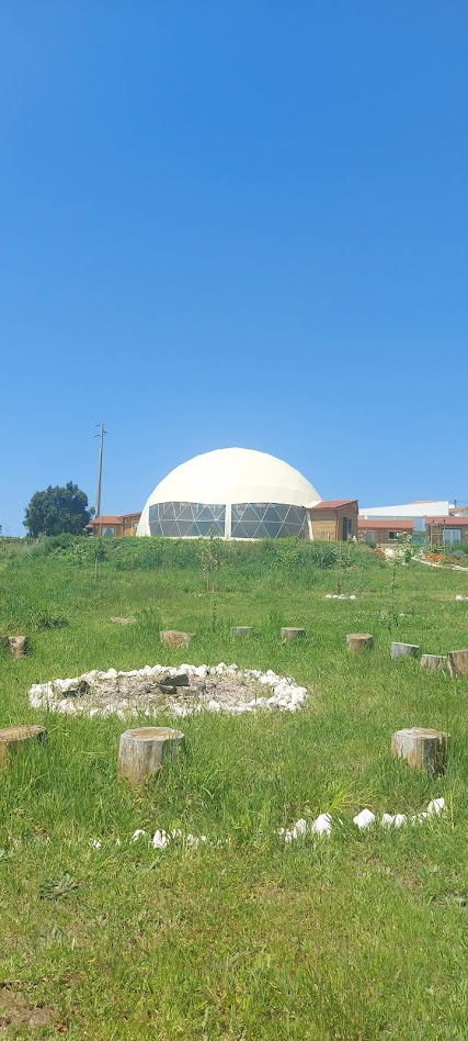 A cúpula do Recanto Paz & Amor vista do jardim, com o círculo de fogo