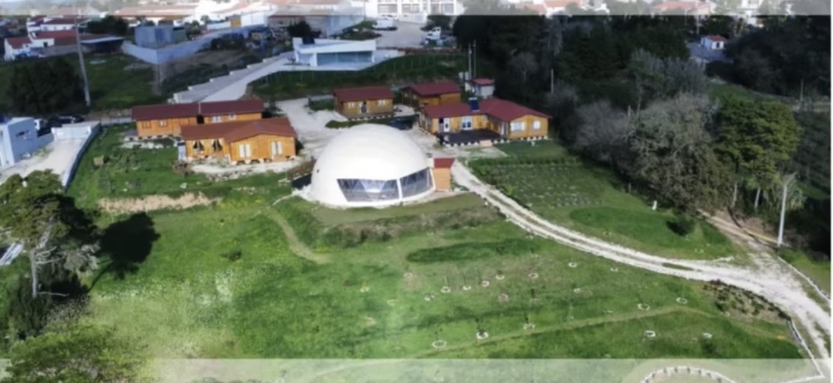 Vista aérea do Recanto Paz & Amor, com a cúpula e as casinhas de madeira